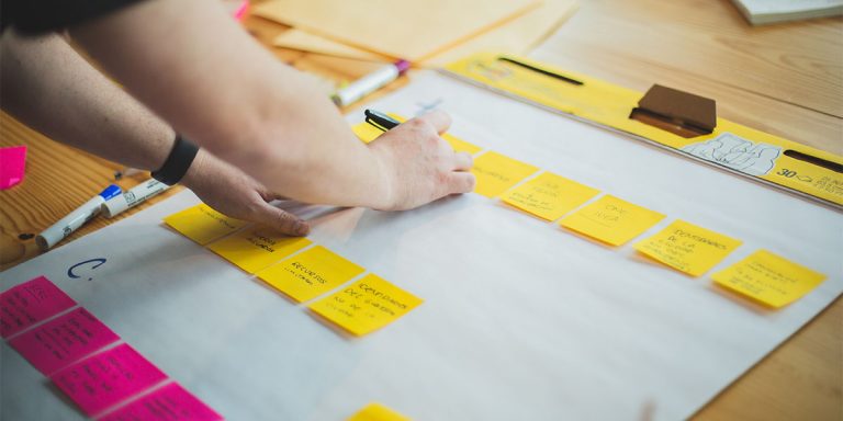 Man writing on post it notes on a desk