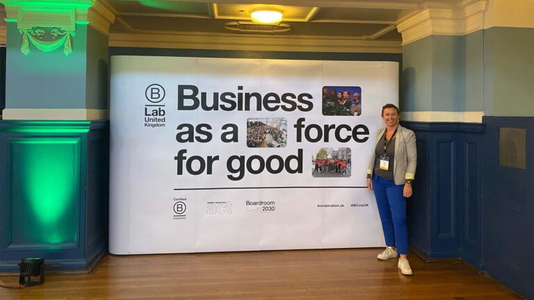 Suzie in front of B Lab sign saying "Business as a force for good"